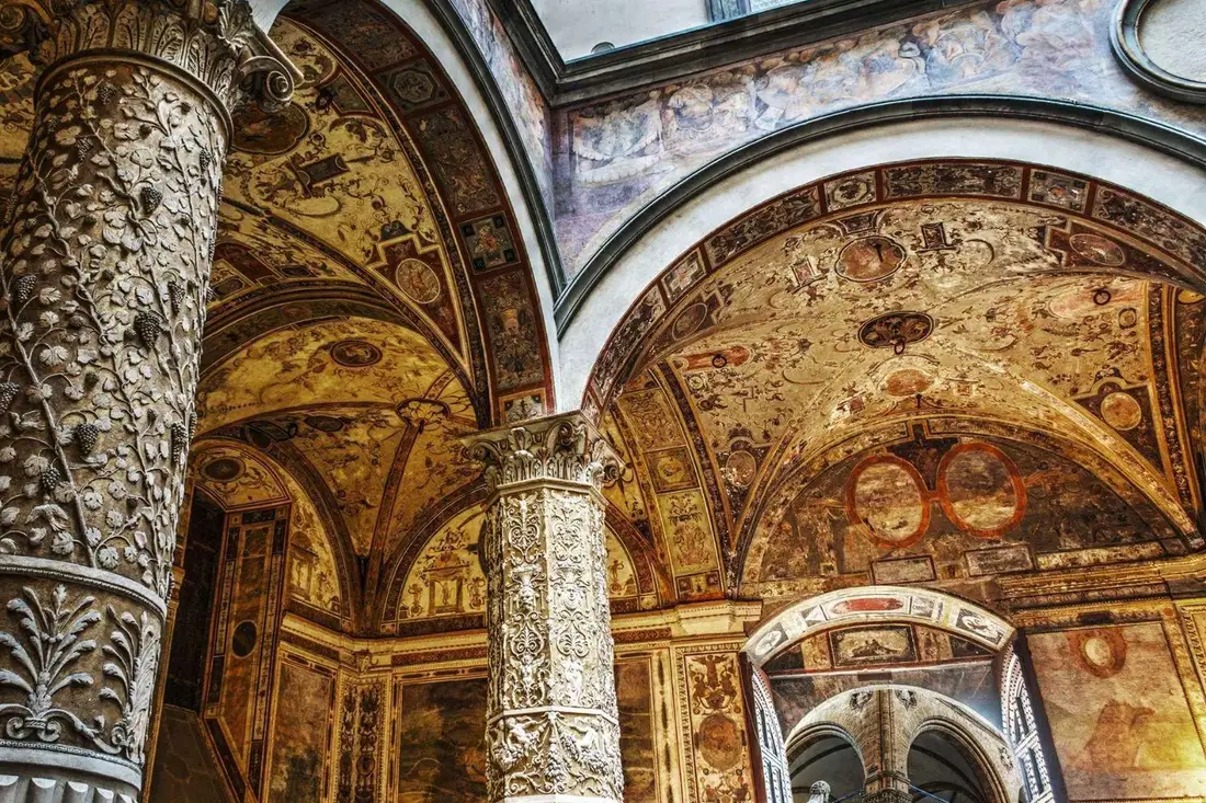 Michelozzo's frescoed courtyard with carved columns inside Palazzo Vecchio, among the great art museums in Florence, Italy