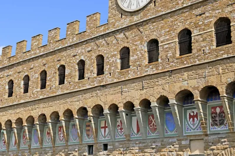 The crenellated stone facade of Palazzo Vecchio on Piazza della Signoria, one of the historic museums in Florence, Italy